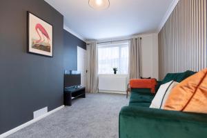 uma sala de estar com um sofá verde e uma televisão em Stanhope House em Stockton-on-Tees