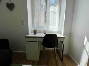 a desk with a chair in front of a window at Appartement Climatisé / Centre-ville / 2 personnes in Besançon