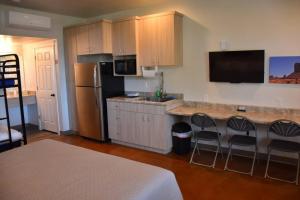 a kitchen with a sink and a counter with chairs at Bunkhouse 6A With Fridge and Microwave in La Verkin