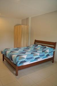 um quarto com uma cama com um edredão azul em บ้านช้าง ด่านขุนทด(Ban Chang Dankhunthod) em Ban Huai Lam Choeng Krai