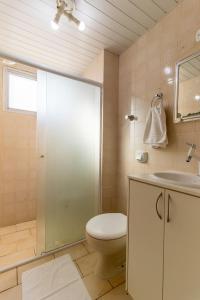 y baño con aseo, ducha y lavamanos. en NVR64B - Quadra Mar, TV Smart, 2DR Climatizado, en Balneário Camboriú