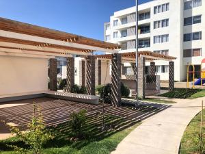 a pergola on a deck in front of a building at Hermoso Jardines del Pacifico in La Serena
