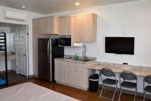 a kitchen with a refrigerator and a counter with chairs at Bunkhouse 3B With Full Bath in La Verkin