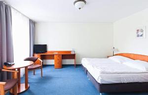 um quarto de hotel com uma cama e uma secretária com um computador em Amore Mio Stare Miasto Apartamenty em Elblag