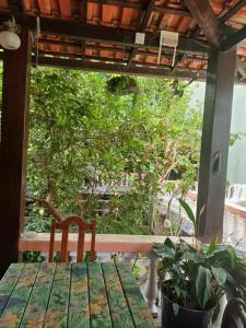 una mesa y una silla en un porche con un árbol en Pousada Minha Terra, en Abraão