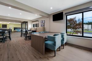 a dining room with a table and chairs and a large window at Sleep Inn Madison in Madison