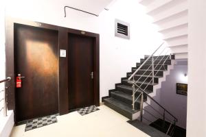 a black door in a hallway with stairs at OYO Hotel Plaza Inn in Bhopal