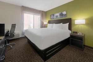 a hotel room with a large bed and a desk at Sleep Inn Madison in Madison +36 photos