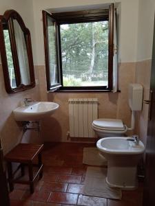 een badkamer met een toilet, een wastafel en een raam bij Antica Riserva in Castiglione del Lago