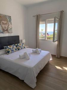 a bedroom with a large white bed with a window at Sea Escape 2 in Almuñécar