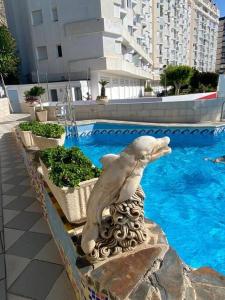 a statue of a seal on a ledge next to a swimming pool at Sea Escape 2 in Almuñécar