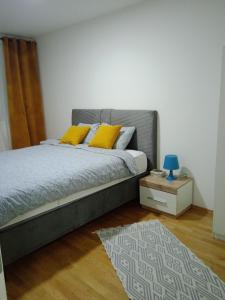 塞拉耶佛的住宿－Apartman Zana，一间卧室配有一张带黄色枕头和地毯的床