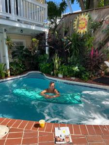 a man in a swimming pool in at The Garden House in Key West