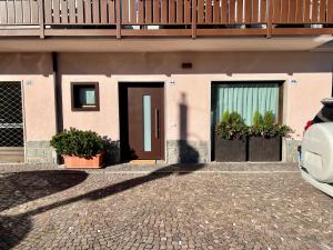 una puerta de una casa con un coche aparcado delante en Casa Salvaterra Suite 44, en Pinzolo