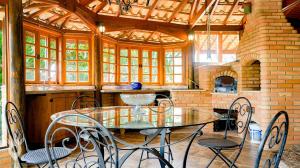 uma cozinha com uma mesa de vidro e cadeiras em Casa Europeia com Lareira & Piscina em Indaiatuba em Indaiatuba