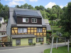 una casa amarilla y marrón con techo negro en Haus am Bach Arnsfeld en Arnsfeld