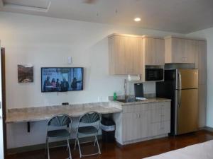 a kitchen with a counter with two chairs and a refrigerator at Bunkhouse 1A Near Zion in La Verkin