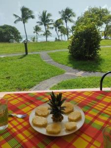 a plate with a pineapple and crackers on a table at Sainte-Anne in Sainte-Anne