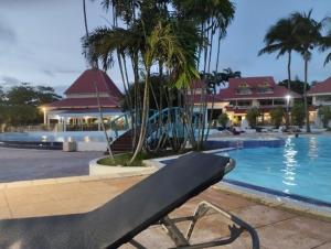a black bench sitting next to a swimming pool at Sainte-Anne in Sainte-Anne