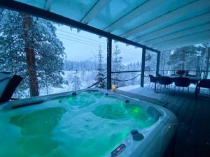 a jacuzzi tub on the deck of a house at Northern Light Villa Ylläs with a Jacuzzi in Ylläsjärvi