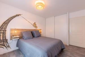 a bedroom with a large bed with a lamp at Appartement Cosy très proche Disney in Coupvray