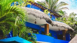 a blue house with palm trees in front of it at Casa Pata Salada in Sayulita +12 photos