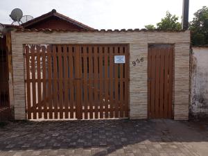 un garage con cancello in legno con un cartello sopra di Casa com piscina em Mongaguá a Mongaguá