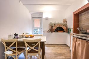 a kitchen with a table and chairs and a fireplace at PIEDS DANS L'EAU in Bogliasco