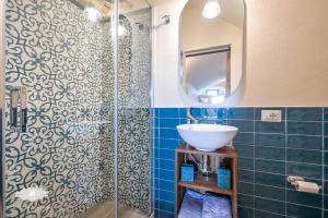 ein Bad mit einem Waschbecken und einer Dusche mit einem Spiegel in der Unterkunft PIEDS DANS L'EAU in Bogliasco