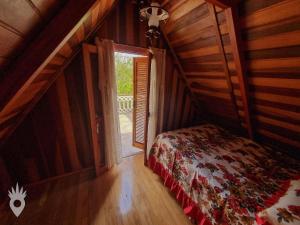 um quarto com uma cama e uma porta aberta em Chalé europeu com vista para natureza no interior em Indaiatuba