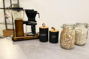 a counter with a blender and three jars of granola at Stylish Scandinavian Suite - Sauna, Harbor & Free Parking in Helsinki