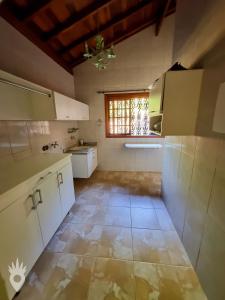 a kitchen with white cabinets and a window at Casa com Piscina & Área Gourmet em Indaiatuba in Indaiatuba