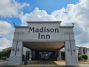 a building with the name of a madison inn at Madison Inn & Suites in Madison