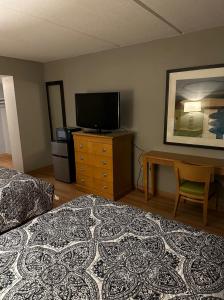 a bedroom with a bed and a flat screen tv at Madison Inn & Suites in Madison