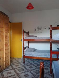 a bedroom with two bunk beds and a door at Hostel Resende in Resende