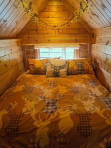 um quarto com uma cama num chalé de madeira em The Cabin at Ashleigh House em Gaerwen