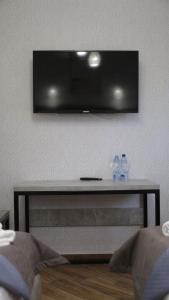 a television on a wall with two bottles on a table at Gallery Elit Hotel in Dunaivtsi
