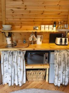 a kitchen with a counter top with a microwave at The Cabin at Ashleigh House in Gaerwen