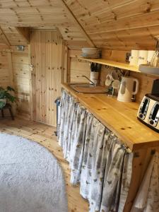 uma cozinha com um balcão num chalé de madeira em The Cabin at Ashleigh House em Gaerwen