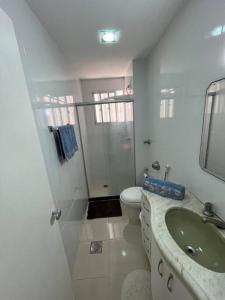 a white bathroom with a sink and a toilet at Aloha aluguel para temporadas in Vitória