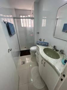 bagno bianco con lavandino e servizi igienici di Aloha aluguel para temporadas a Vitória