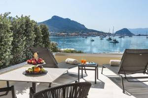 un tavolo e sedie su un balcone con vista sull'acqua di Gabbiano Azzurro Hotel & Suites a Golfo Aranci