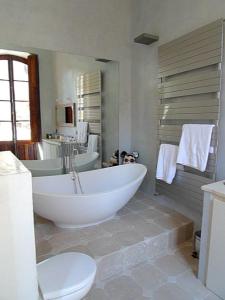 a bathroom with a large white tub and a toilet at Luxury two bedroom apartment in Apt, the heart of the Luberon in Apt +8 photos