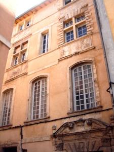 an old building with windows on a city street at Luxury two bedroom apartment in Apt, the heart of the Luberon in Apt