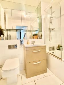 a bathroom with a toilet and a sink and a shower at Captivating 1-Bed Apartment Greater London in Belvedere