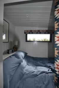 a bedroom with a large bed with a window at Twin Barn Shepherd’s Huts in Norwich