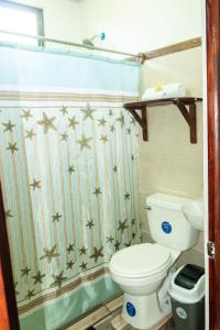 a bathroom with a toilet and a shower curtain at Residencia las brisas Griegas in Quepos