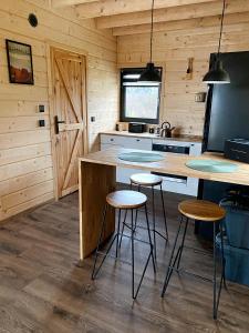 a kitchen with a counter and stools in a cabin at Duchałówka 2.0 in Koszarawa +15 photos