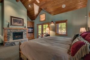um quarto com uma cama grande e uma lareira em New Listing! West Shore Bliss - 4BR, Private Hot Tub em Tahoe City