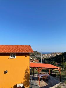 een geel huis met een tafel en een dak bij La casa dell'ulivo in Imperia